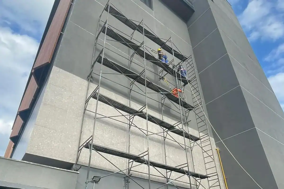 Andaime fachadeiro em fachada de edifício, com trabalho em altura