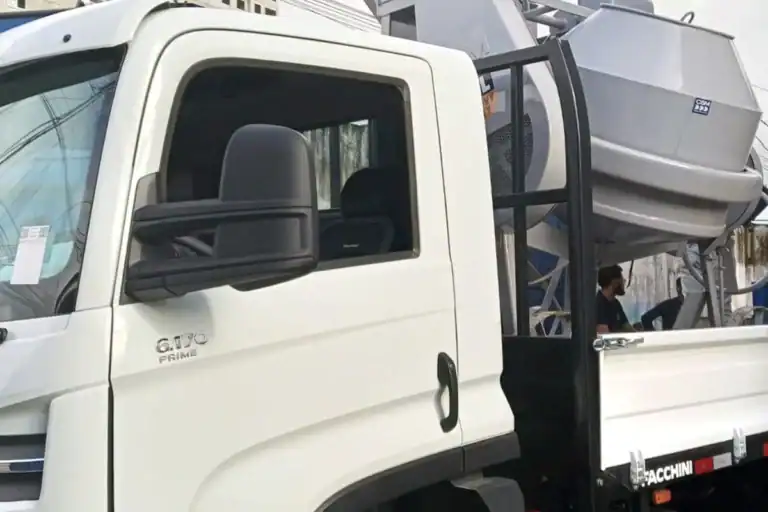 Caminhão da frota da Prático Locações transportando uma betoneira