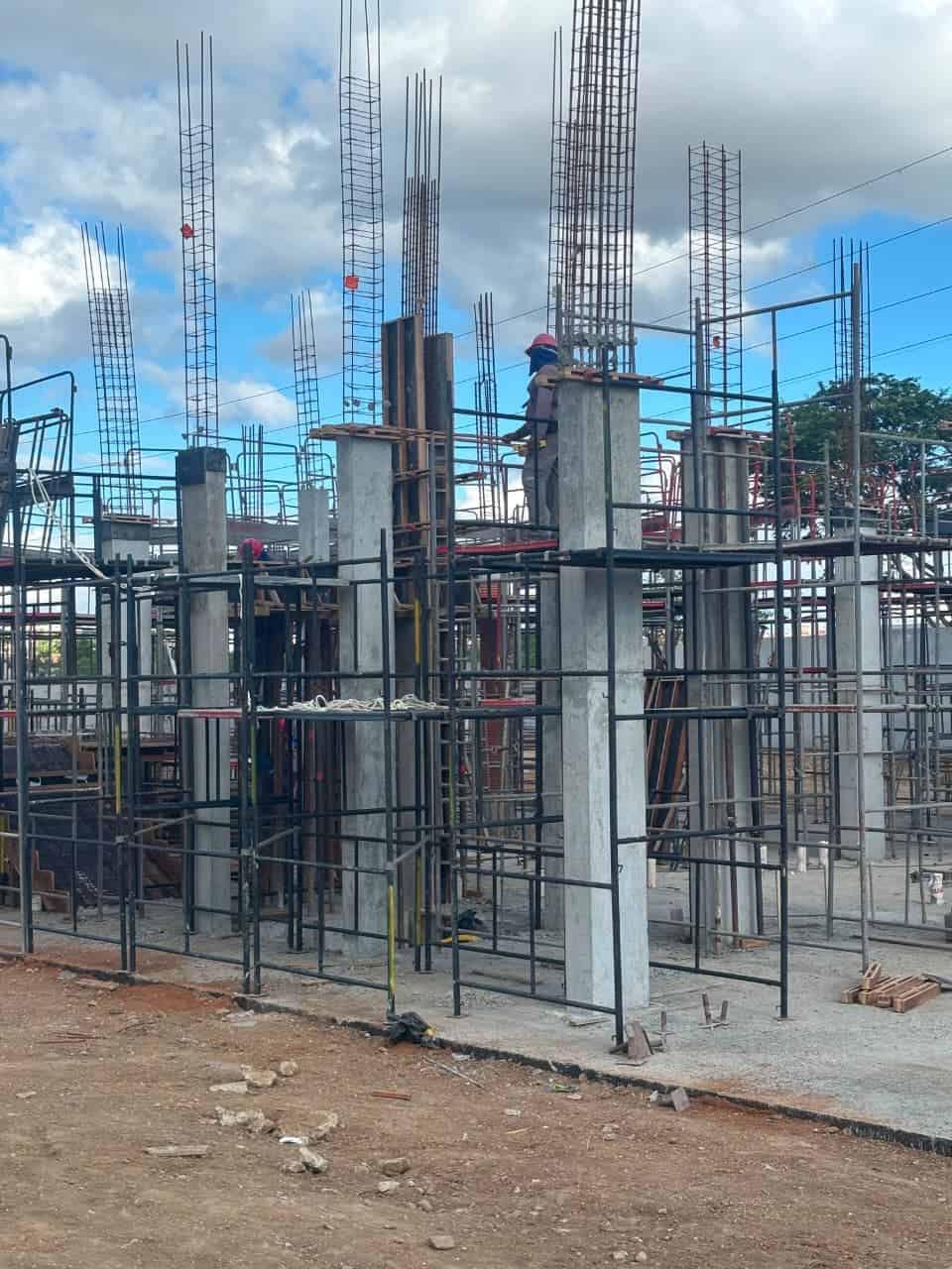 Obra em estrutura no Recife com torres de andaime tubular e escoras metálicas, com trabalhadores no andaime