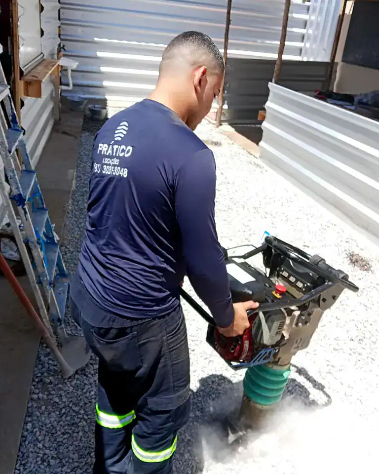 Compactador de percussão tipo sapo da Prático Locações compactando brita em obra no Recife