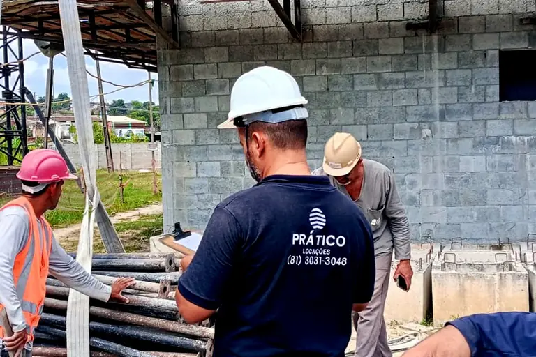 Técnico da Prático Locações conferindo na prancheta as escoras metálicas entregues na obra